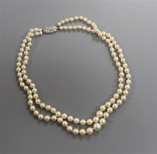 A double strand graduated cultured pearl necklace, with diamond set white metal clasp, 38cm.